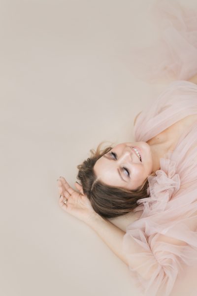 woman-close-up-portrait-photo-beige-studio-background-happy-smiley-face.jpg