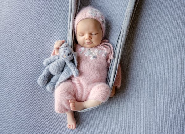 newborn-baby-girl-smiling-sleeping-makeshift-swing-photoshoot.jpg