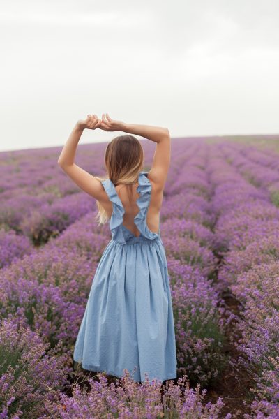 young-smiling-blonde-long-hair-woman-blue-dress-lavender-field-naked-shoulder-posing-model-5.jpg