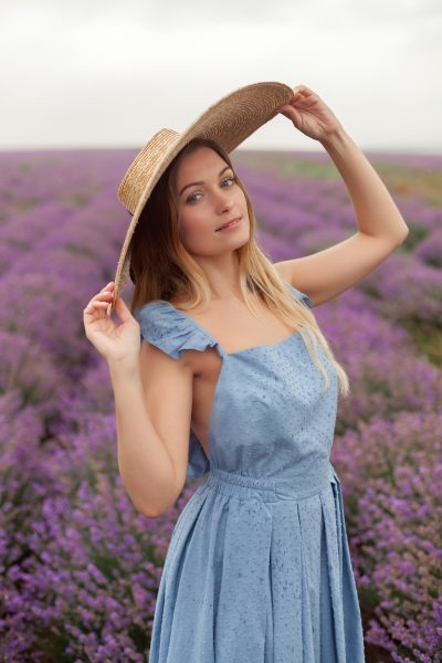 blonde-woman-round-wicker-hat-blue-dress-rain-lavender-field.jpg