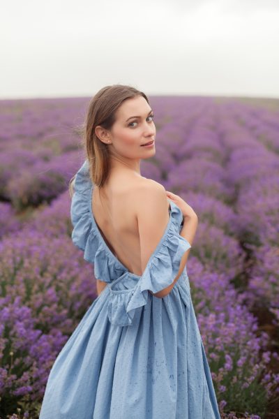 young-smiling-blonde-long-hair-woman-blue-dress-lavender-field-naked-shoulder-posing-model.jpg